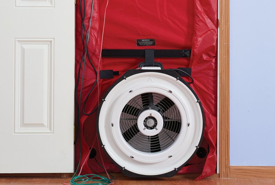 Blower door fan and red fabric panel fitted into an interior doorway for an air-leakage test