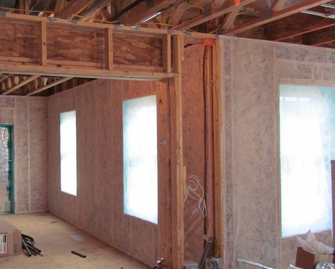 Netting stapled across wood-framed walls ready to hold blown-in cellulose insulation
